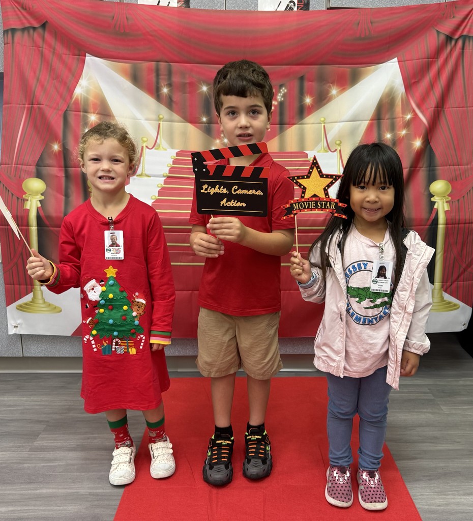 S.T.A.R. Gator Students pose in a room with a red carpet backdrop.