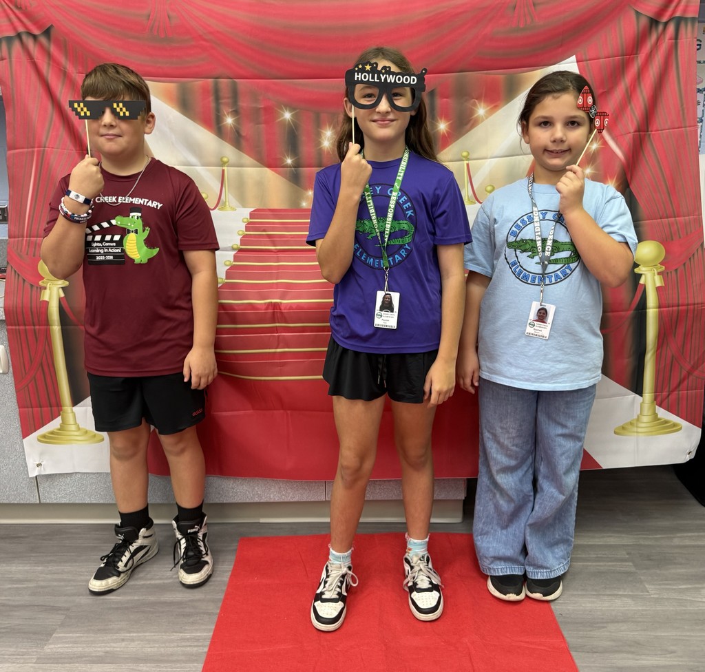 S.T.A.R. Gator Students pose in a room with a red carpet backdrop.