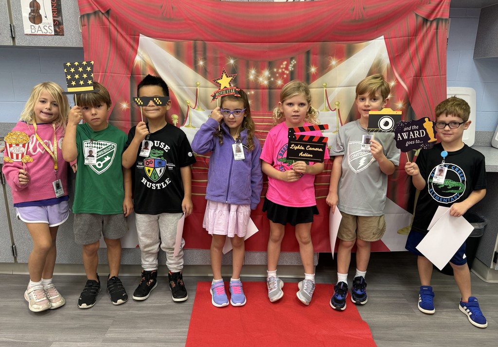 S.T.A.R. Gator Students pose in a room with a red carpet backdrop.