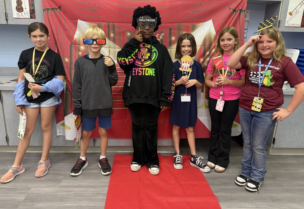 S.T.A.R. Gator Students pose in a room with a red carpet backdrop.