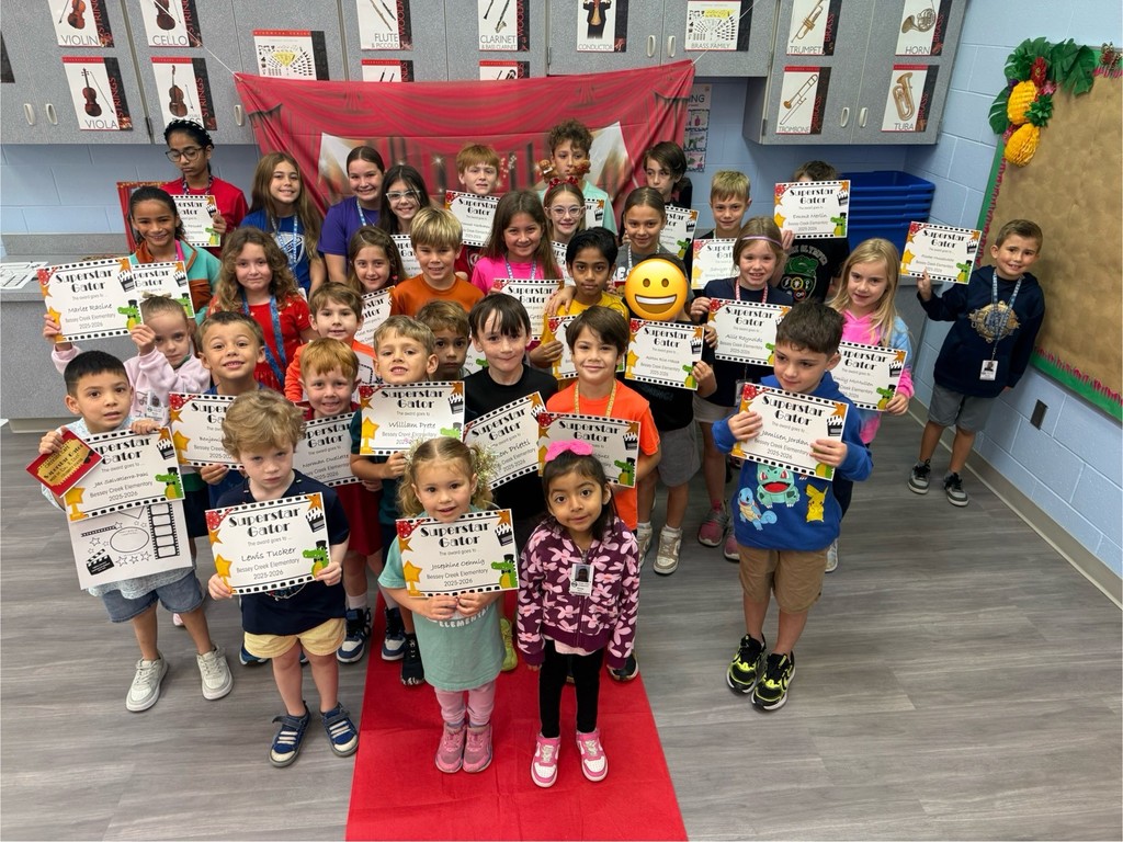 S.T.A.R. Gator Students pose in a room with a red carpet backdrop.