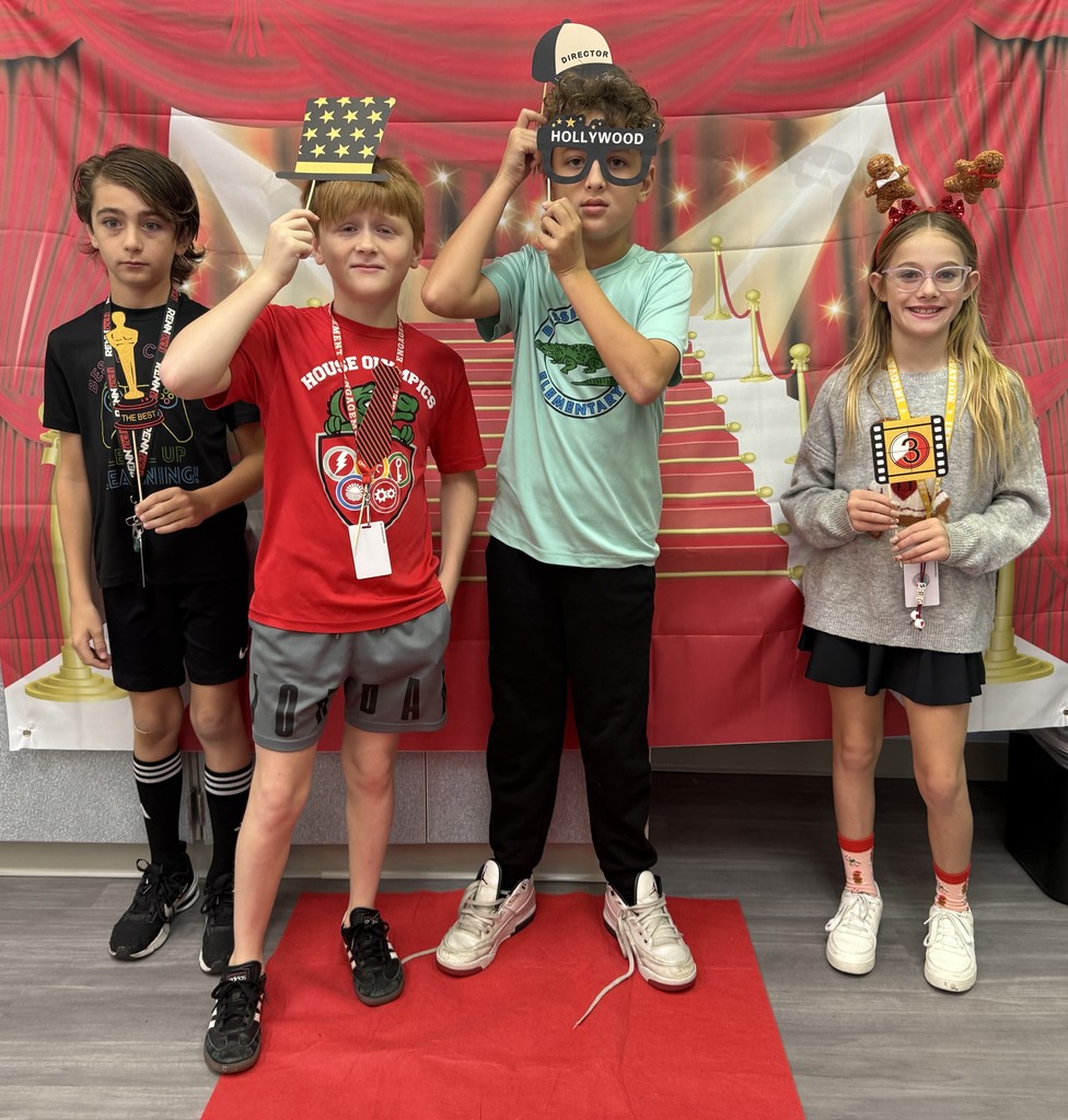 S.T.A.R. Gator Students pose in a room with a red carpet backdrop.