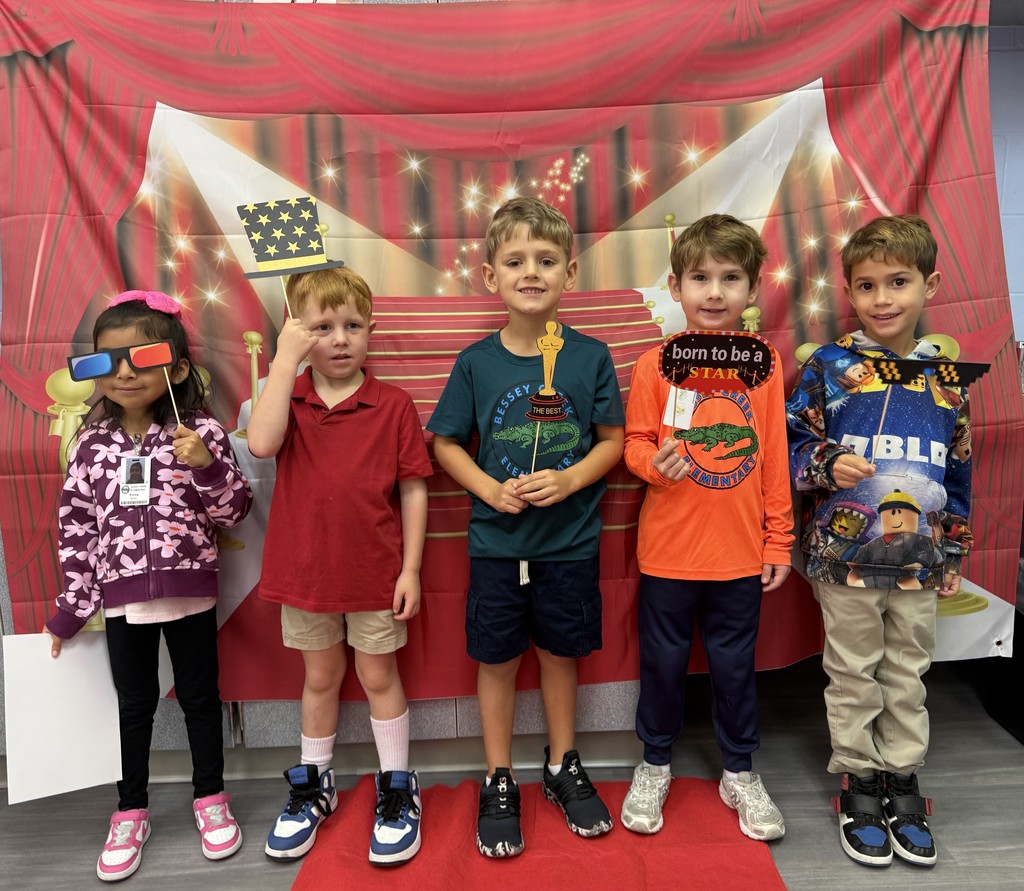 S.T.A.R. Gator Students pose in a room with a red carpet backdrop.