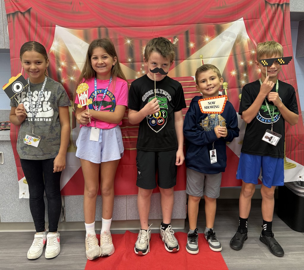 S.T.A.R. Gator Students pose in a room with a red carpet backdrop.