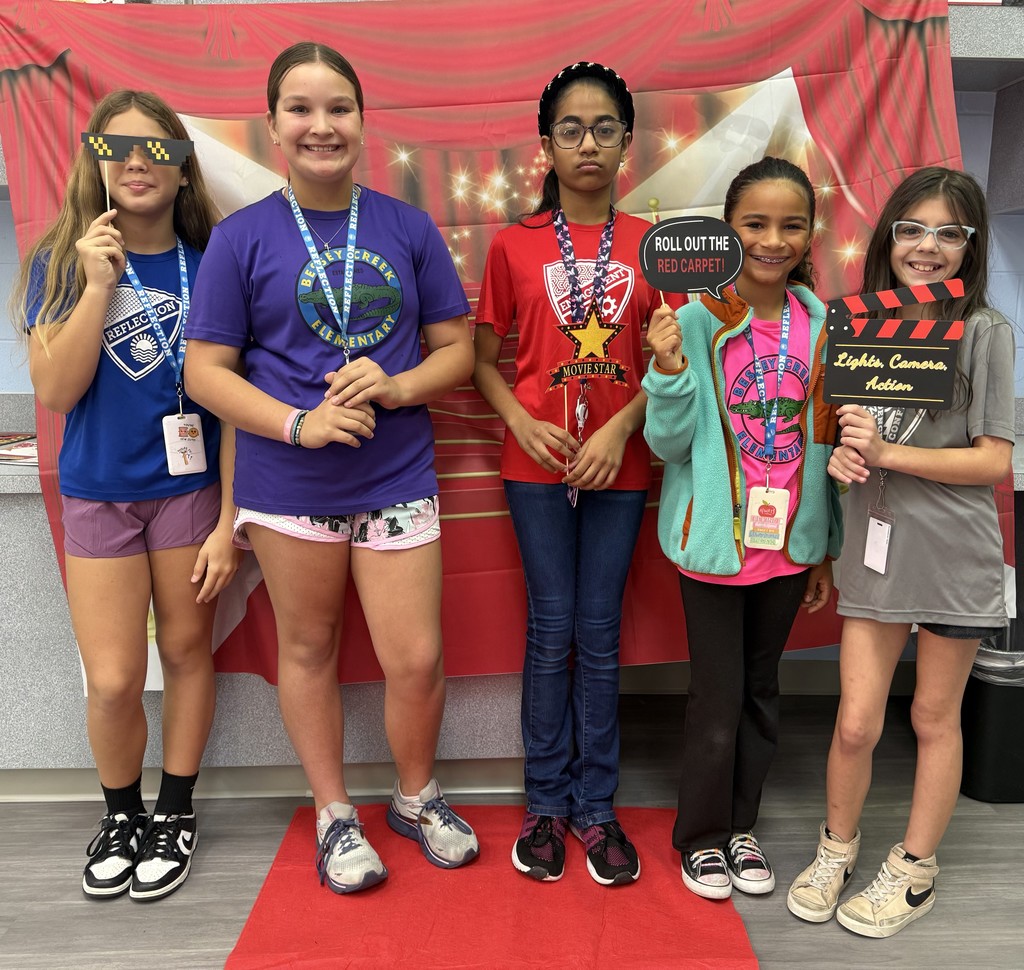 S.T.A.R. Gator Students pose in a room with a red carpet backdrop.