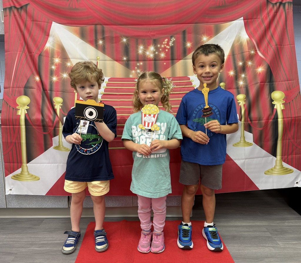 S.T.A.R. Gator Students pose in a room with a red carpet backdrop.