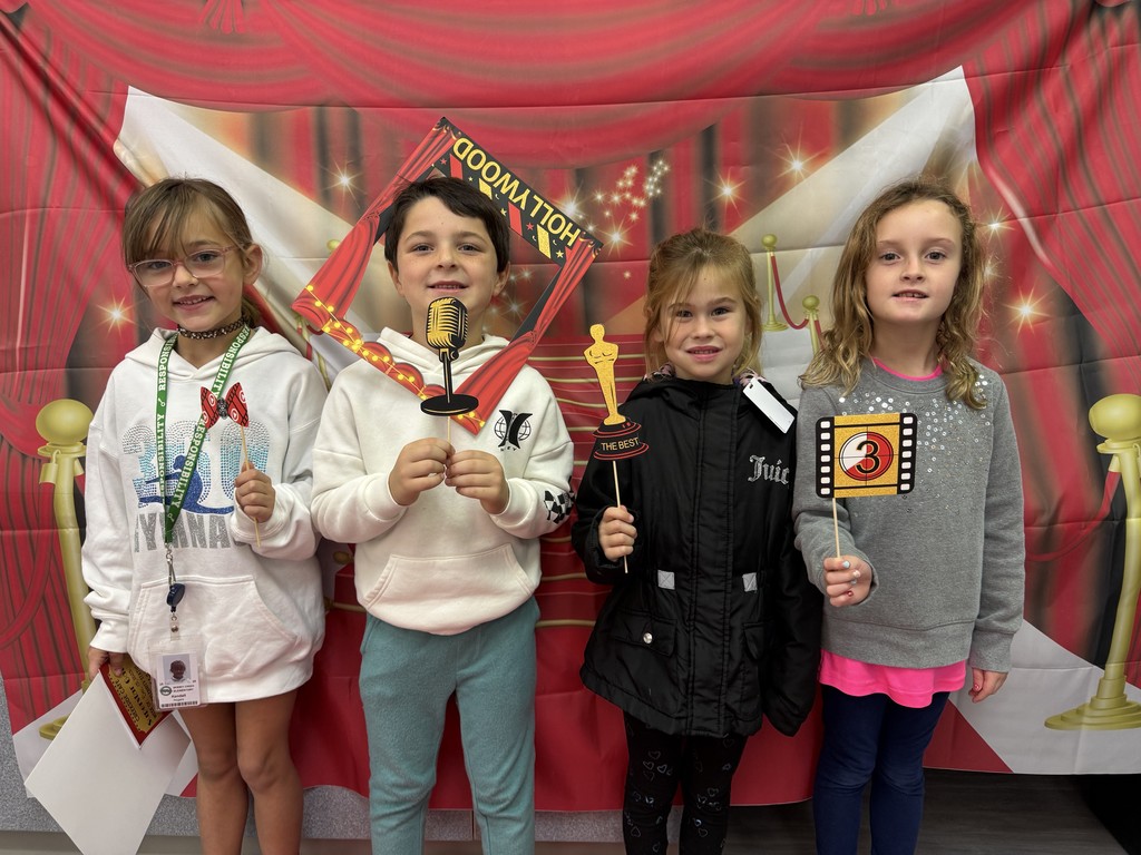 S.T.A.R. Gator Students pose in a room with a red carpet backdrop.