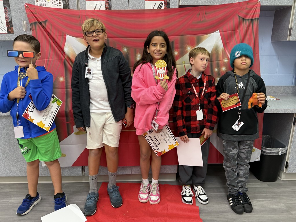 S.T.A.R. Gator Students pose in a room with a red carpet backdrop.
