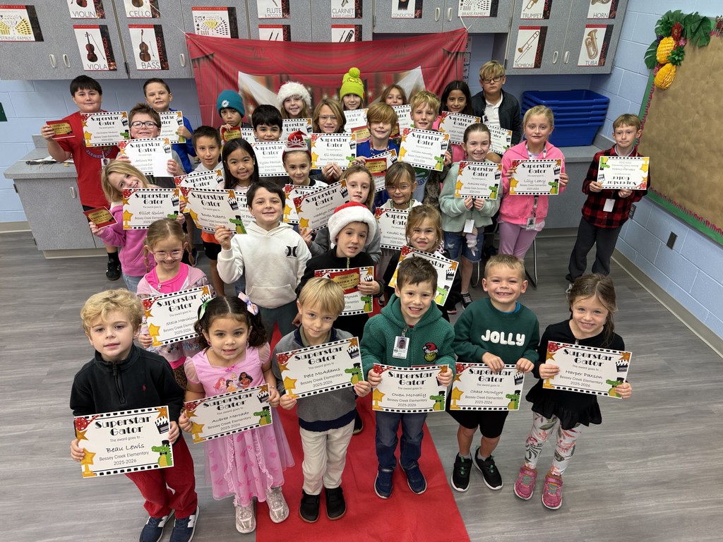 S.T.A.R. Gator Students pose in a room with a red carpet backdrop.