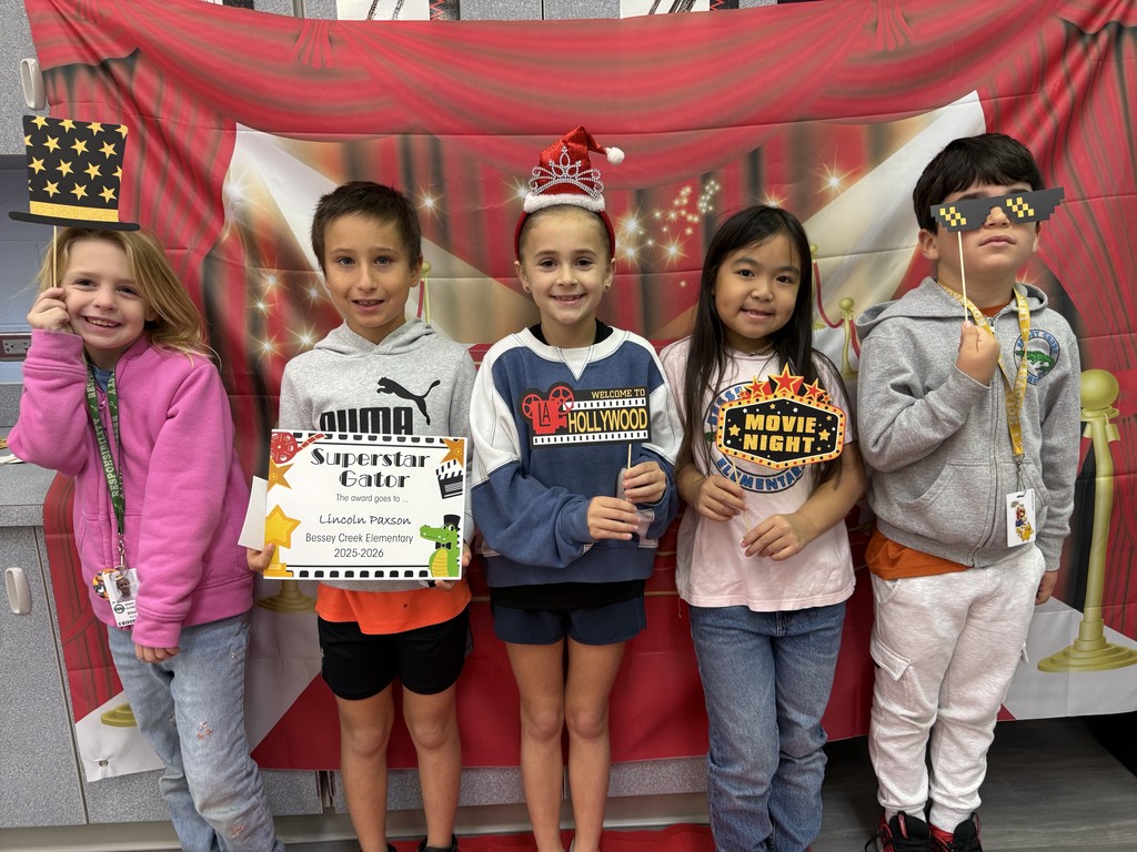 S.T.A.R. Gator Students pose in a room with a red carpet backdrop.