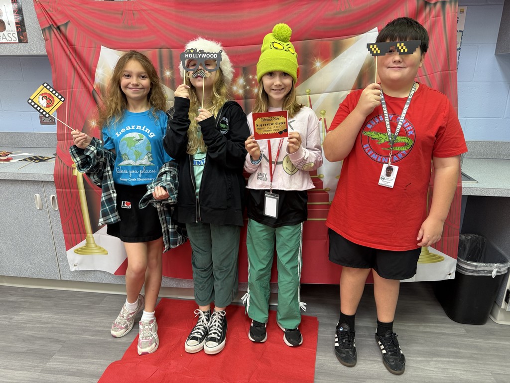 S.T.A.R. Gator Students pose in a room with a red carpet backdrop.