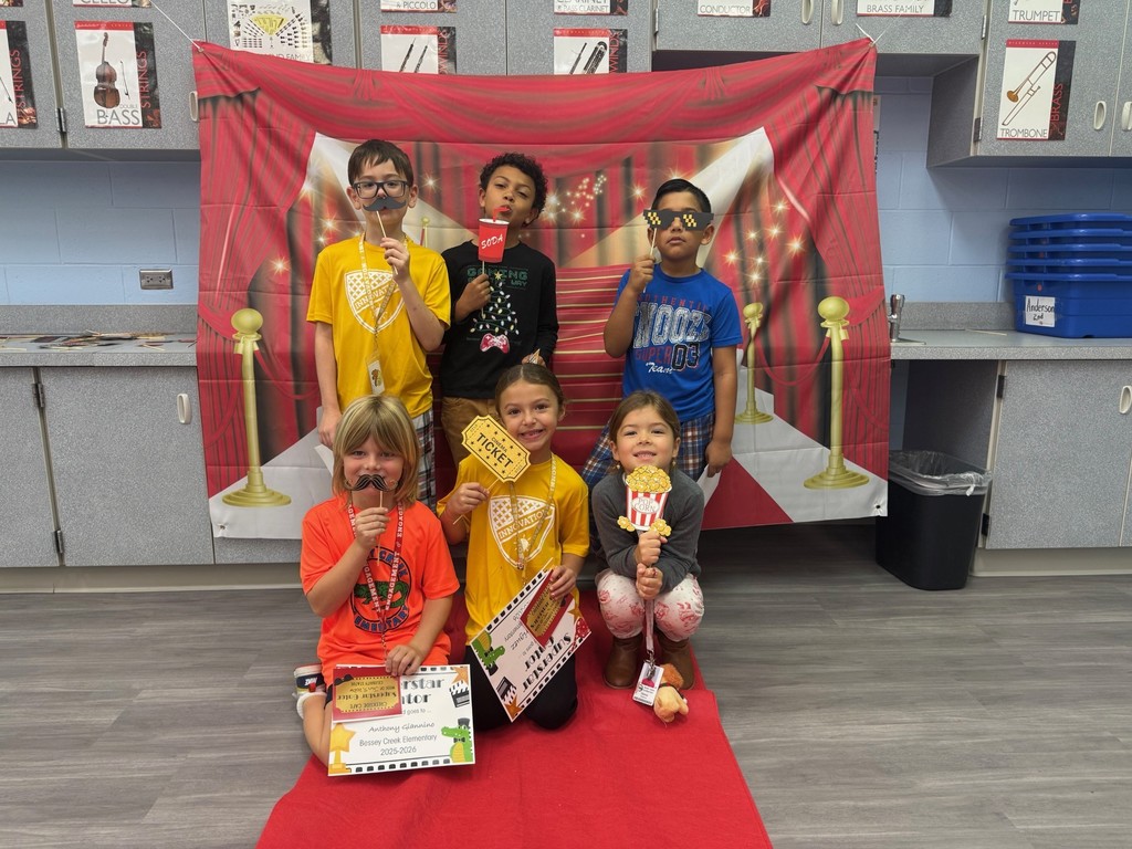 S.T.A.R. Gator Students pose in a room with a red carpet backdrop.