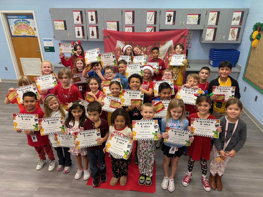 S.T.A.R. Gator Students pose in a room with a red carpet backdrop.