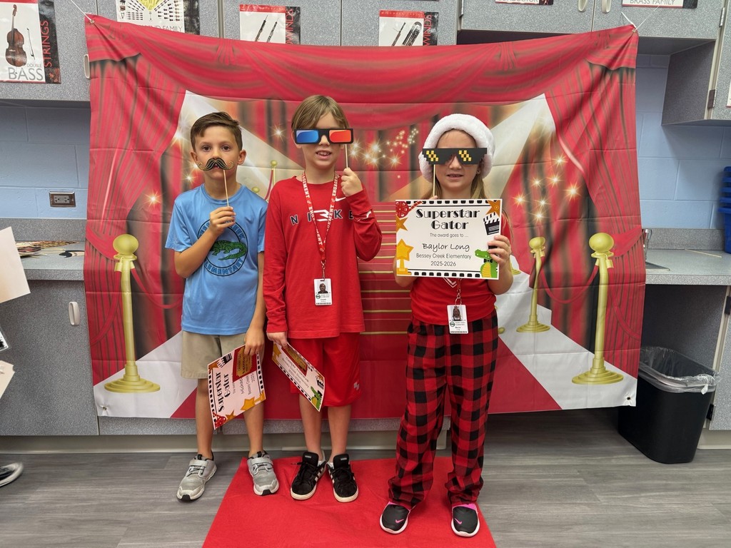 S.T.A.R. Gator Students pose in a room with a red carpet backdrop.
