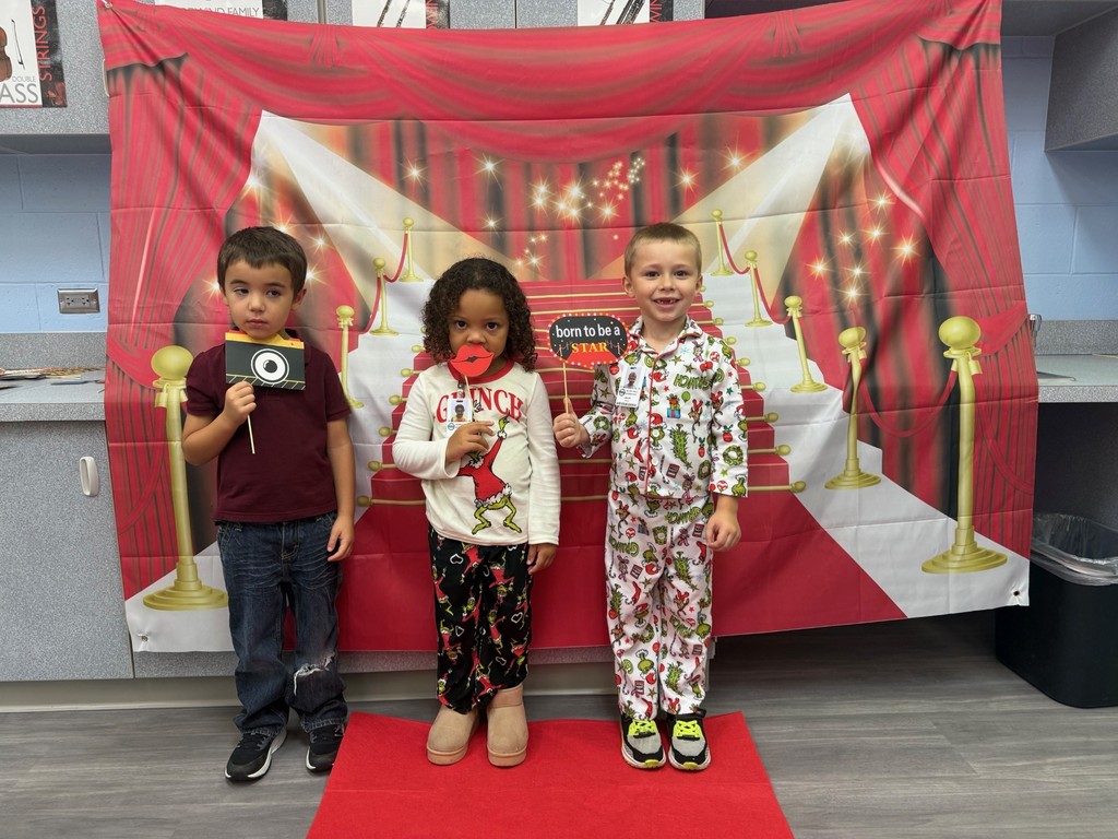 S.T.A.R. Gator Students pose in a room with a red carpet backdrop.