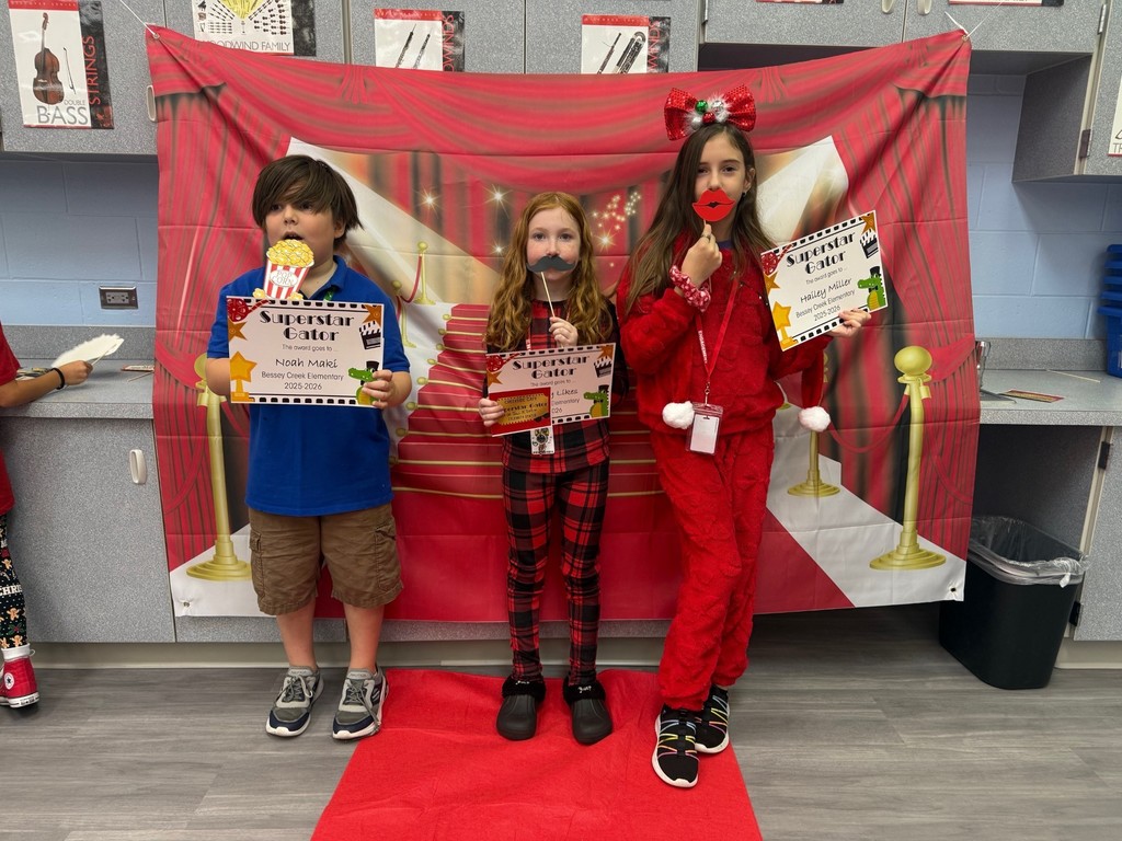 S.T.A.R. Gator Students pose in a room with a red carpet backdrop.