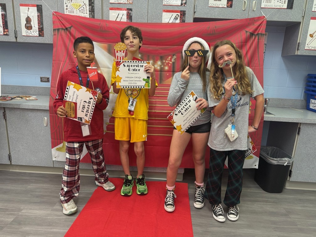 S.T.A.R. Gator Students pose in a room with a red carpet backdrop.