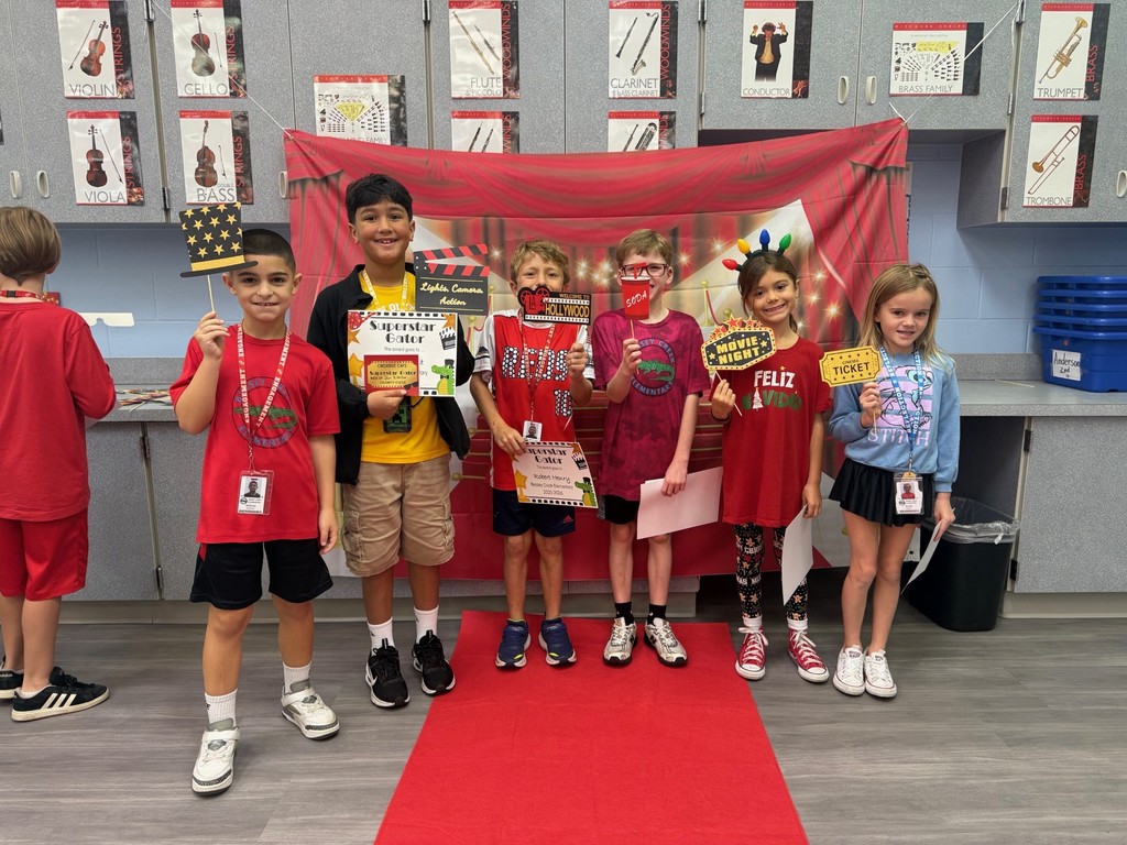 S.T.A.R. Gator Students pose in a room with a red carpet backdrop.