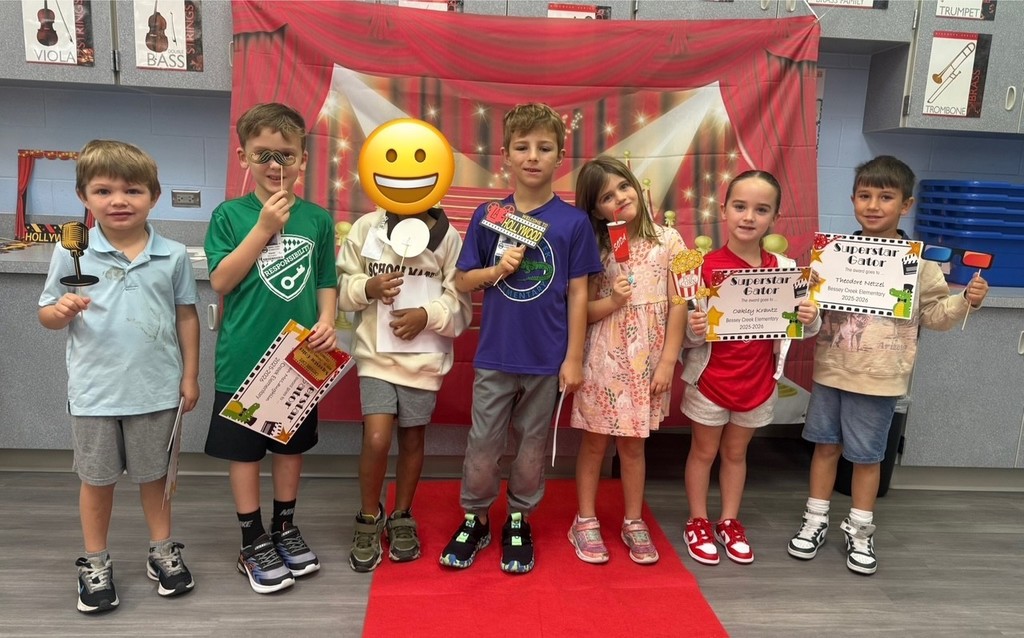 S.T.A.R. Gator Students pose in a room with a red carpet backdrop.