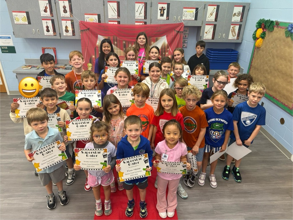 S.T.A.R. Gator Students pose in a room with a red carpet backdrop.