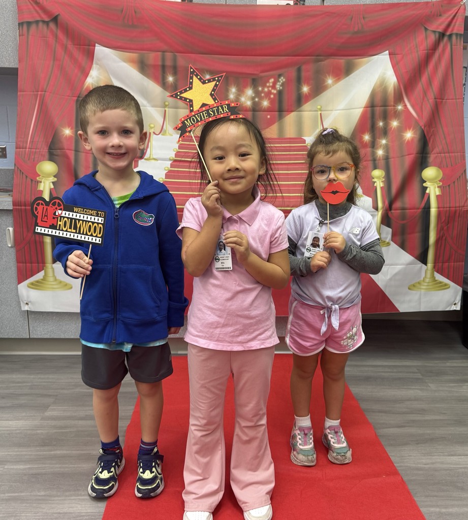 S.T.A.R. Gator Students pose in a room with a red carpet backdrop.