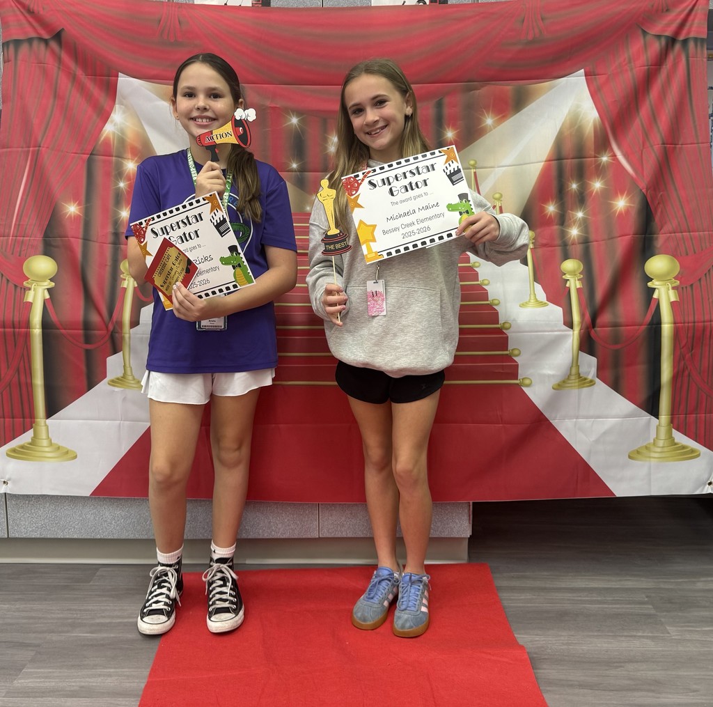 S.T.A.R. Gator Students pose in a room with a red carpet backdrop.