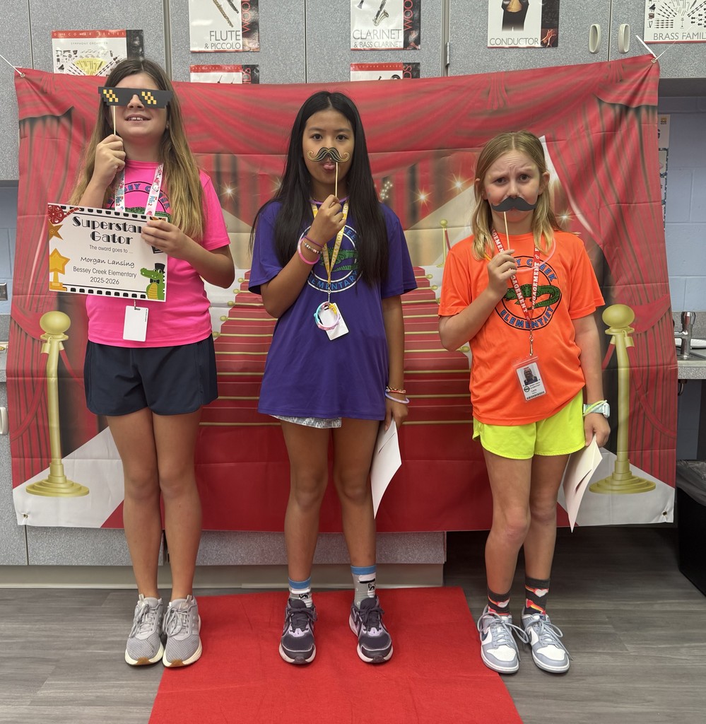 S.T.A.R. Gator Students pose in a room with a red carpet backdrop.