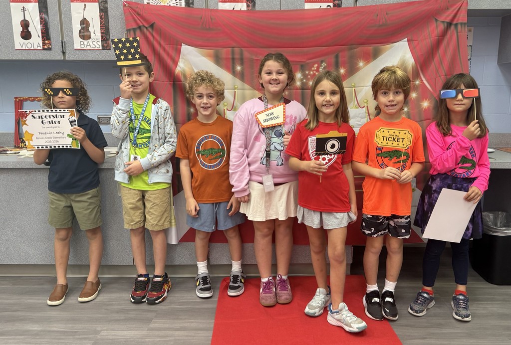 S.T.A.R. Gator Students pose in a room with a red carpet backdrop.