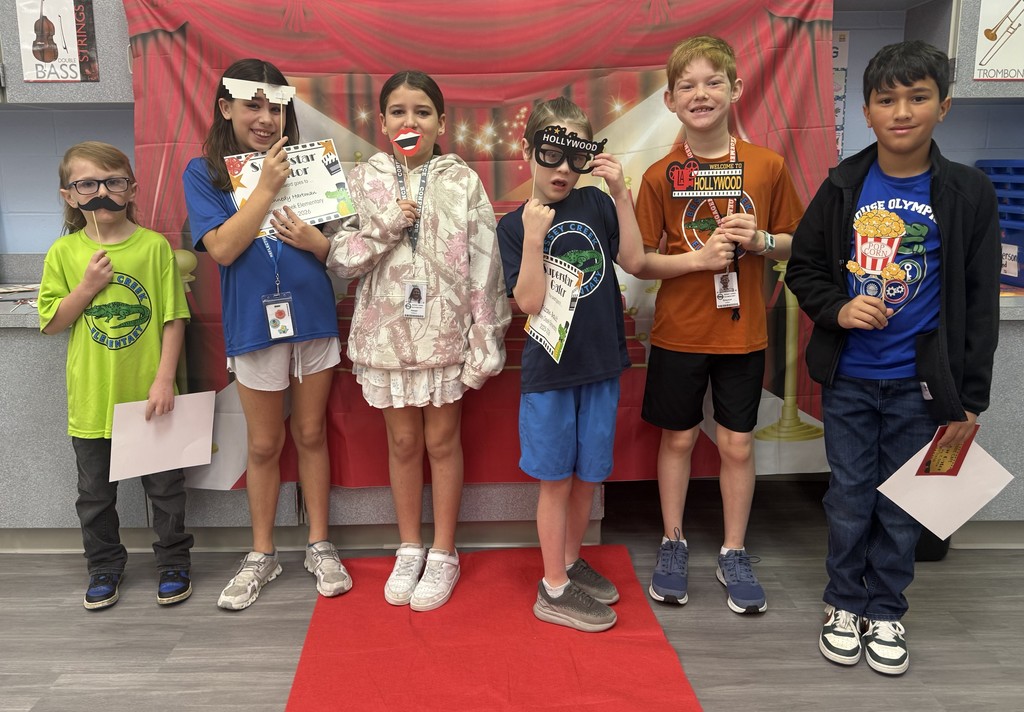 S.T.A.R. Gator Students pose in a room with a red carpet backdrop.