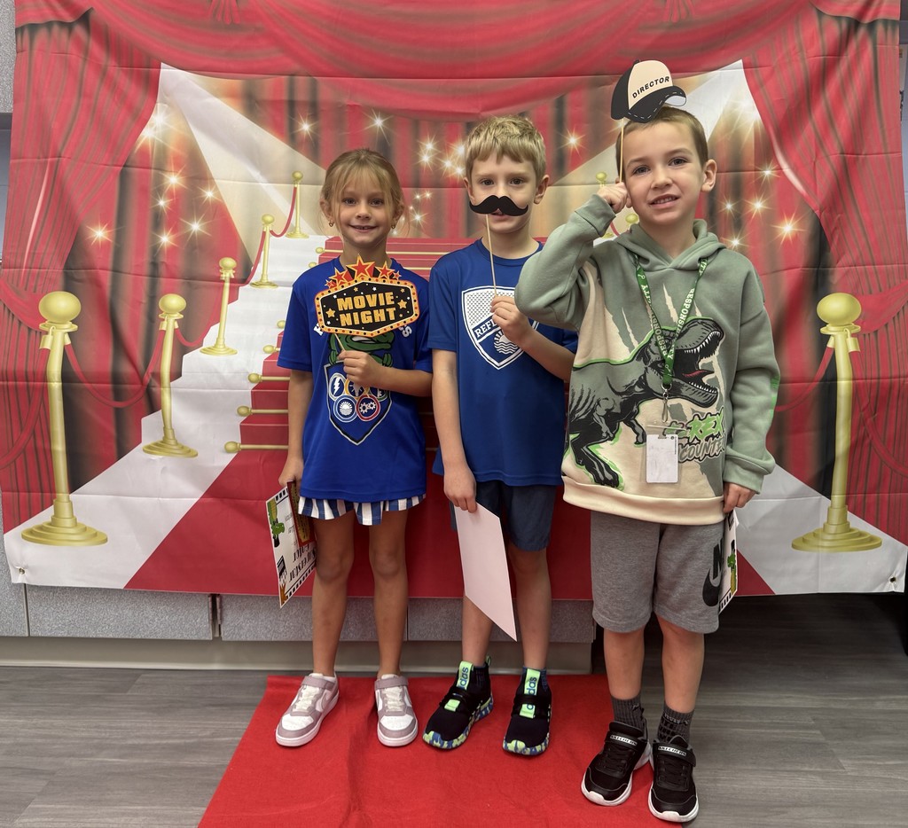S.T.A.R. Gator Students pose in a room with a red carpet backdrop.