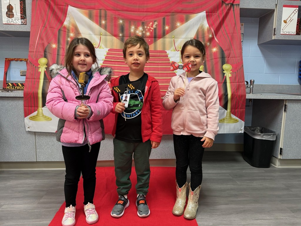 S.T.A.R. Gator Students pose in a room with a red carpet backdrop.