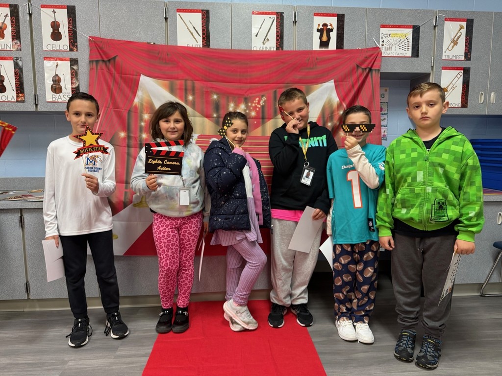 S.T.A.R. Gator Students pose in a room with a red carpet backdrop.