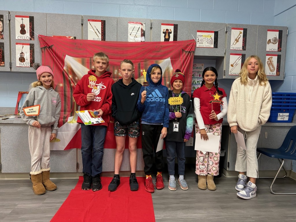 S.T.A.R. Gator Students pose in a room with a red carpet backdrop.