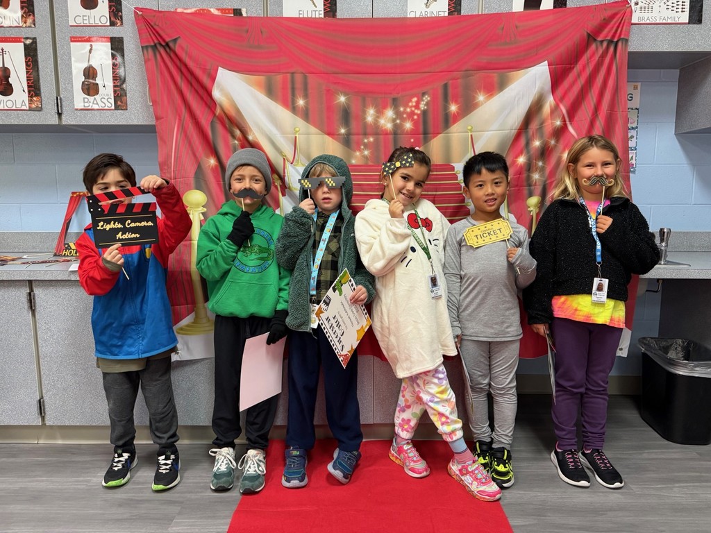 S.T.A.R. Gator Students pose in a room with a red carpet backdrop.