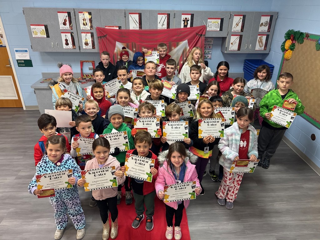S.T.A.R. Gator Students pose in a room with a red carpet backdrop.