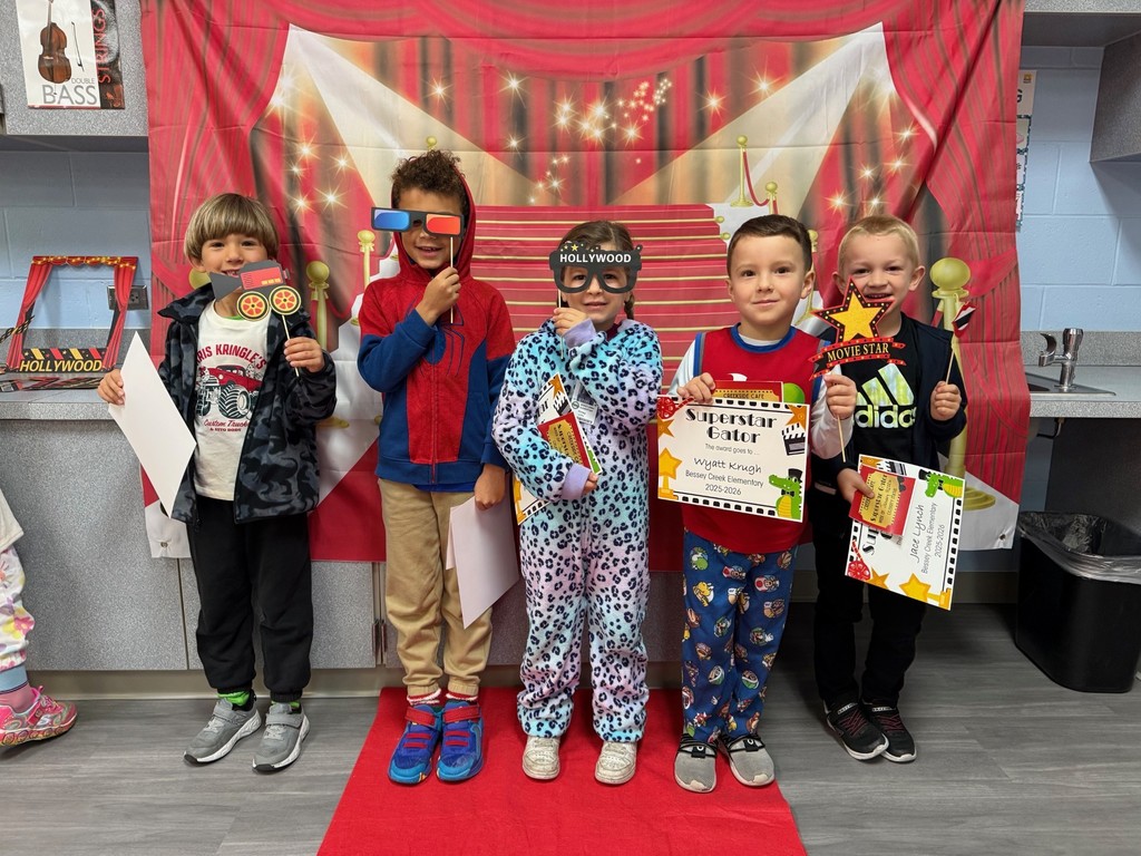 S.T.A.R. Gator Students pose in a room with a red carpet backdrop.