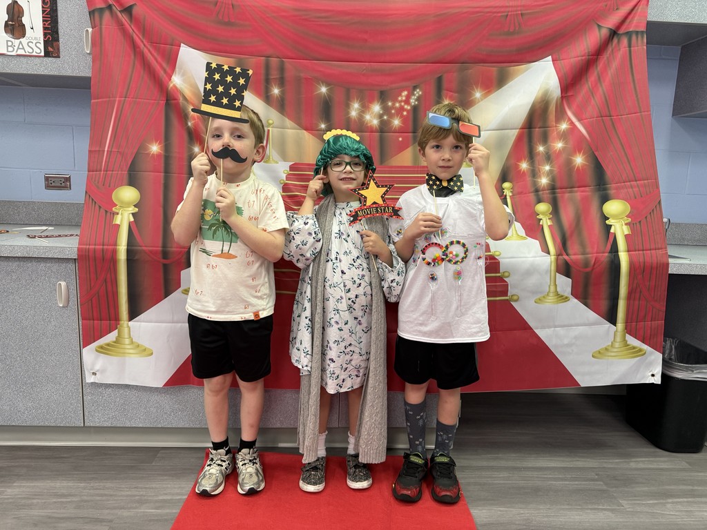 S.T.A.R. Gator Students pose in a room with a red carpet backdrop.