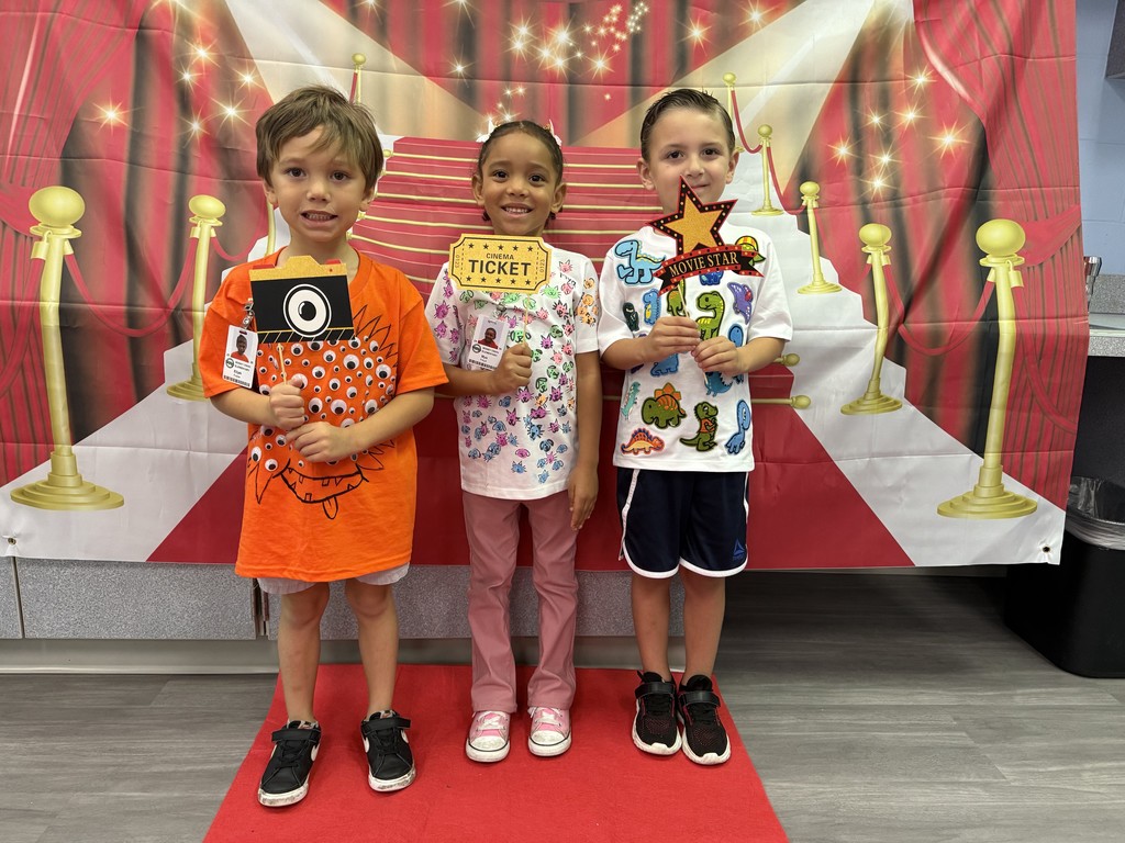 S.T.A.R. Gator Students pose in a room with a red carpet backdrop.