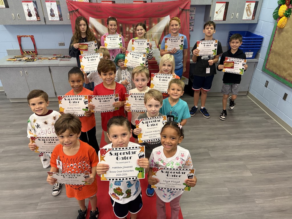 S.T.A.R. Gator Students pose in a room with a red carpet backdrop.