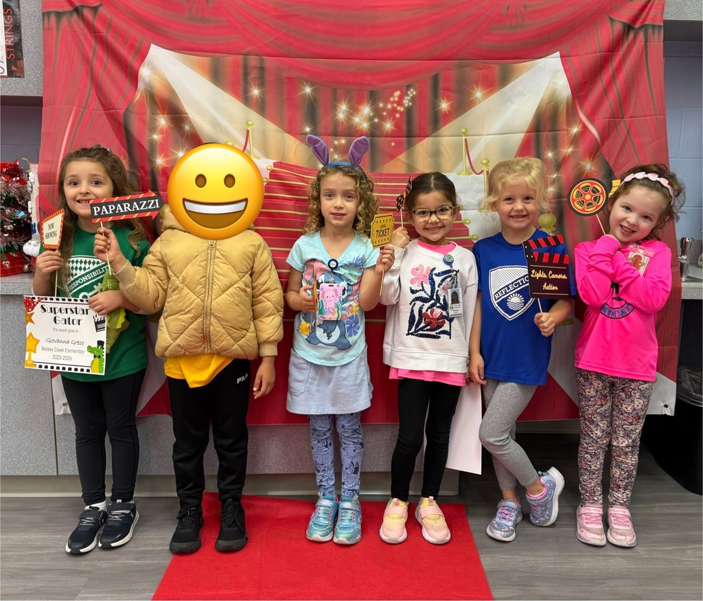 S.T.A.R. Gator Students pose in a room with a red carpet backdrop.