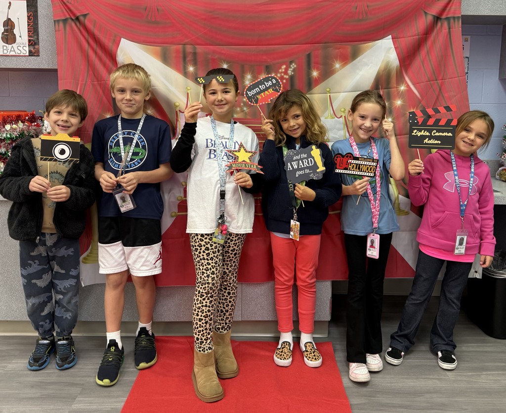 S.T.A.R. Gator Students pose in a room with a red carpet backdrop.