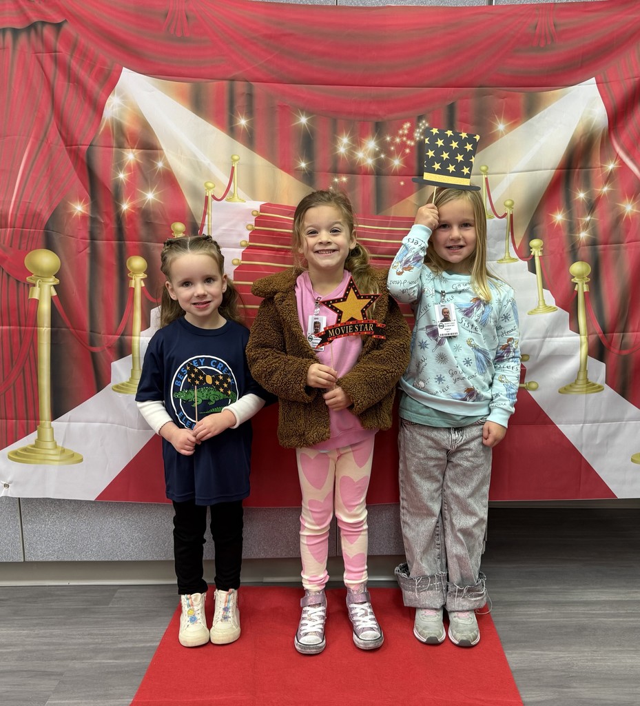S.T.A.R. Gator Students pose in a room with a red carpet backdrop.