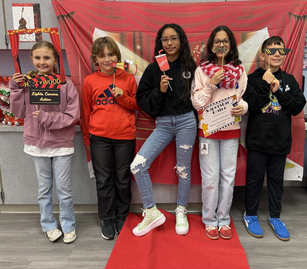 S.T.A.R. Gator Students pose in a room with a red carpet backdrop.