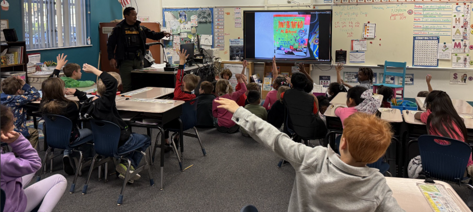 2026 Literacy Week - Ms. Thompson's first grade sharing a book with M.C. Policeman