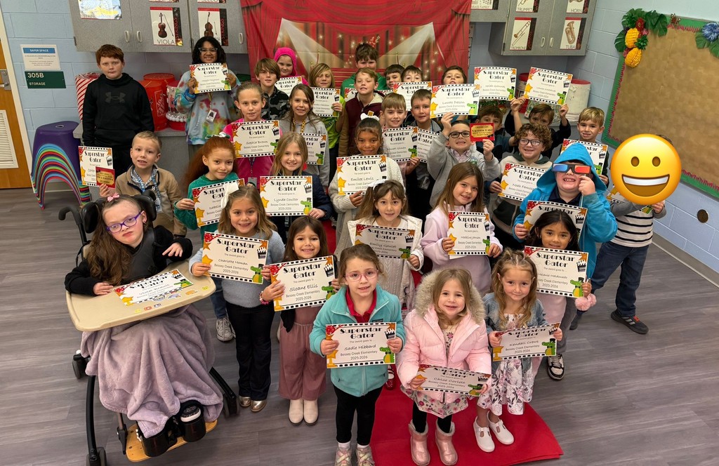 S.T.A.R. Gator Students pose in a room with a red carpet backdrop.
