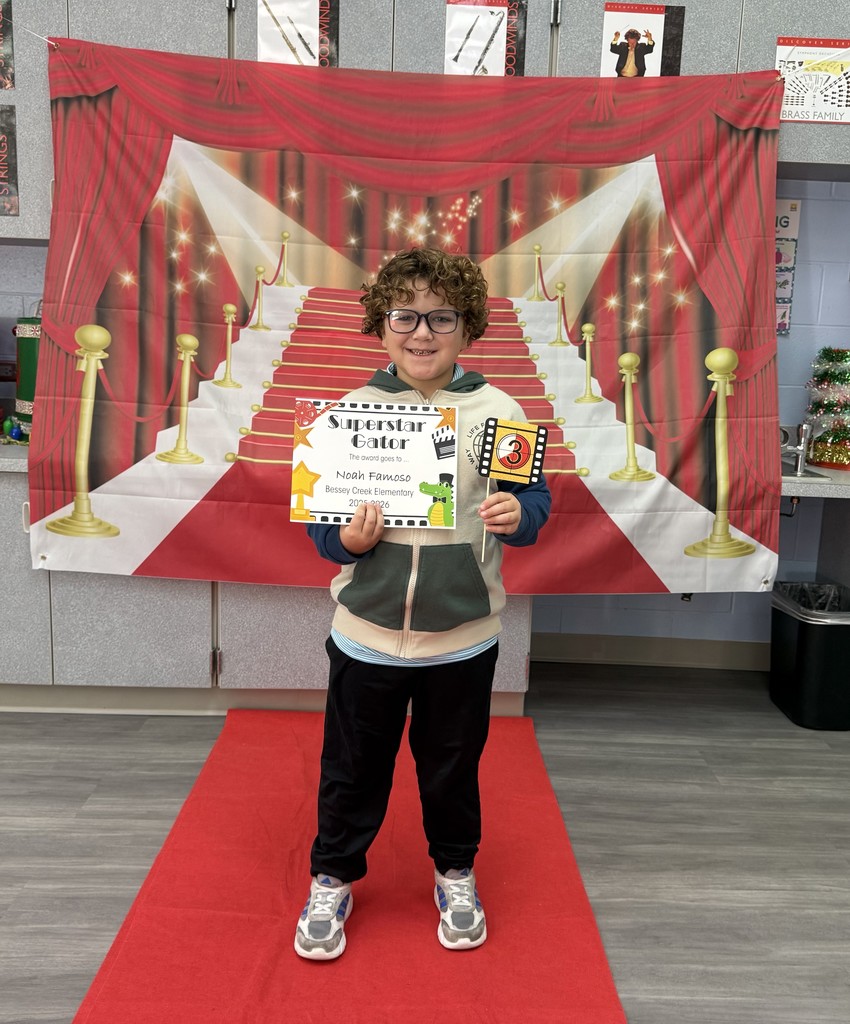S.T.A.R. Gator Students pose in a room with a red carpet backdrop.