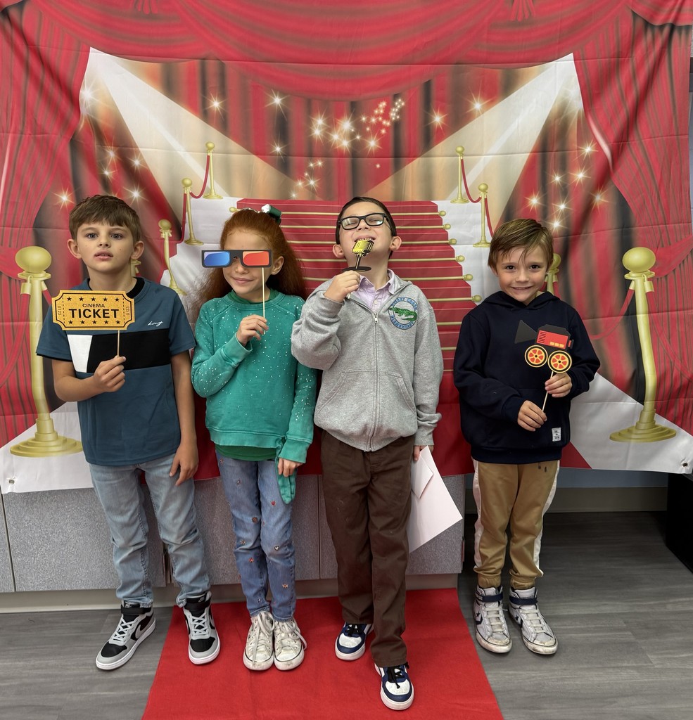 S.T.A.R. Gator Students pose in a room with a red carpet backdrop.