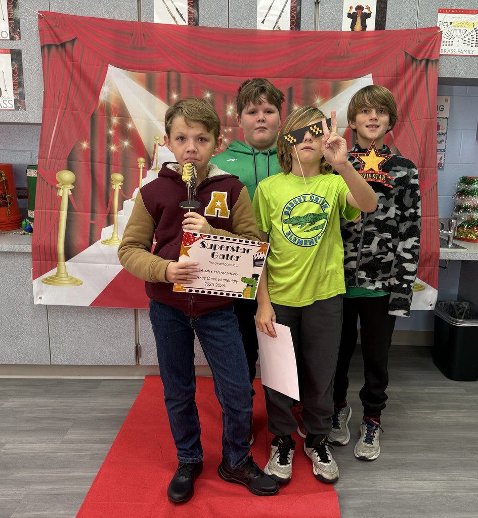 S.T.A.R. Gator Students pose in a room with a red carpet backdrop.