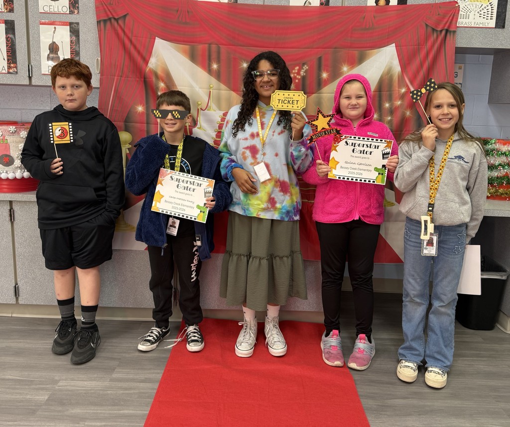 S.T.A.R. Gator Students pose in a room with a red carpet backdrop.