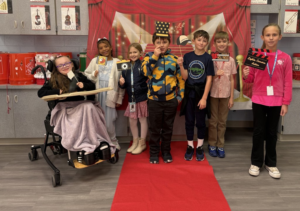 S.T.A.R. Gator Students pose in a room with a red carpet backdrop.